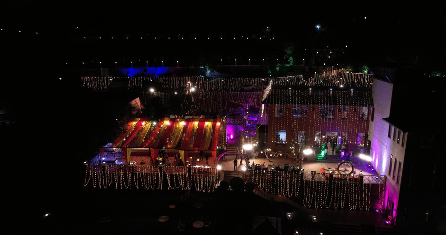 Nighttime event showcases an illuminated outdoor setup with vibrant colourful lights enhancing the decorations - Digantaa Resort in Mukteshwar