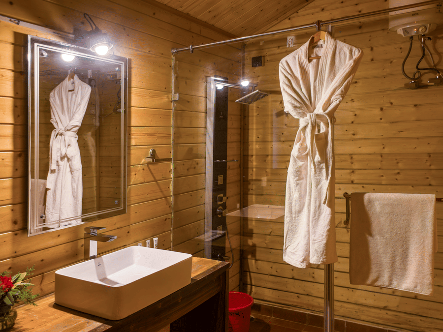  A cozy and well-appointed bathroom with plush robes, a modern sink, and elegant lighting, ensuring a comfortable and relaxing stay - Digantaa Resort in Mukteshwar